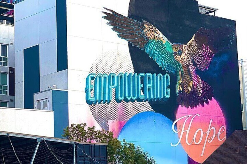 En bygning med et stort mural af en ørn og ordene "EMPOWERING HOPE". 2