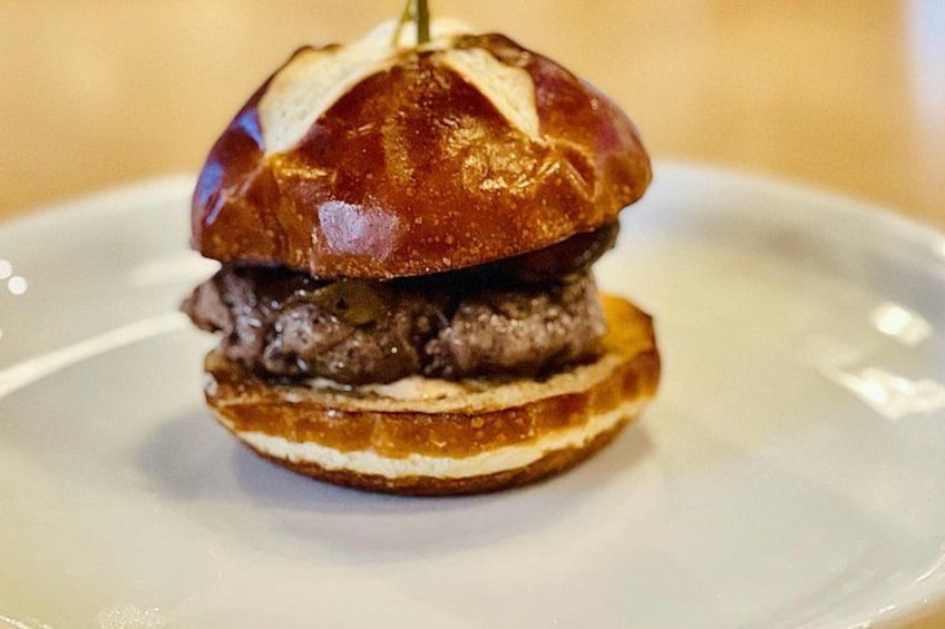 A burger with a glossy bun on a white plate. 5