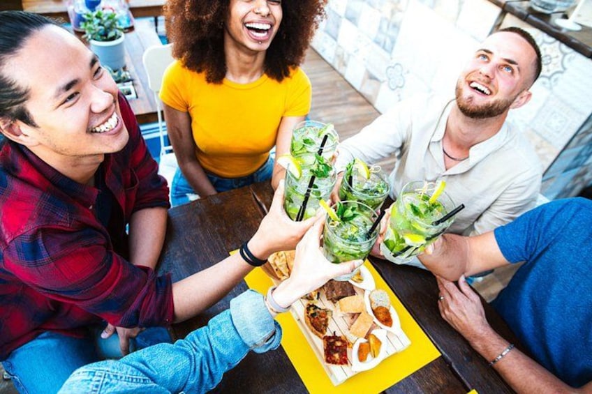 A group of people toasting with drinks at a table. 1
