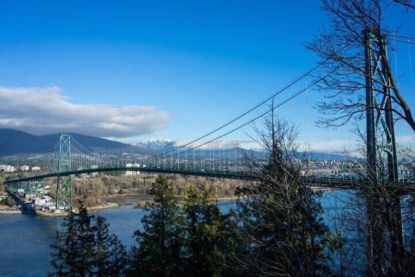 A suspension bridge over a river with mountains in the background. 4