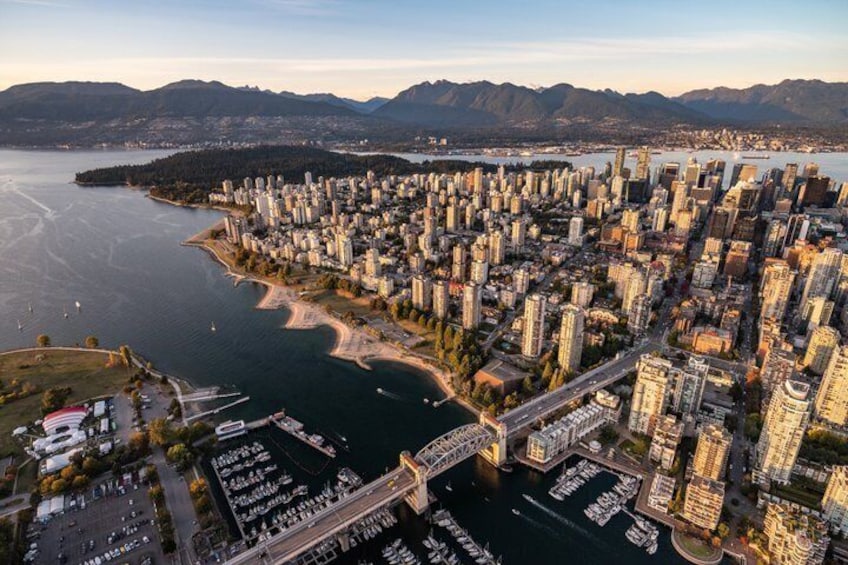A coastal cityscape with dense high-rise buildings, a marina, and a bridge connecting the urban area to a peninsula. 3