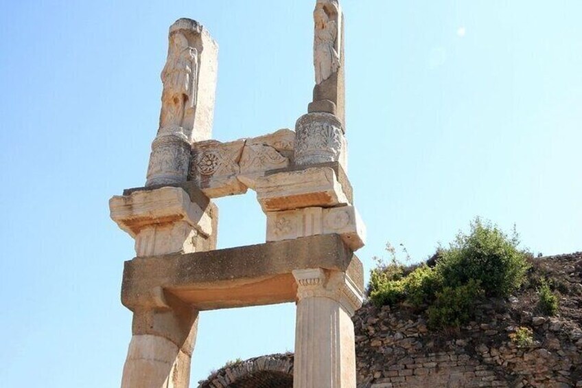 A stone structure with intricate carvings and a clear blue sky in the background. 5