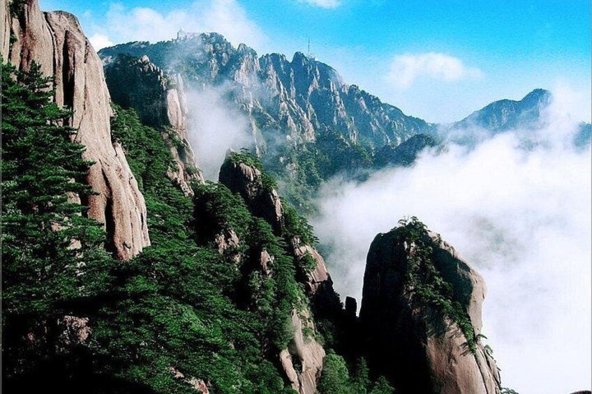 A mountainous landscape with rocky cliffs and dense green vegetation. 5