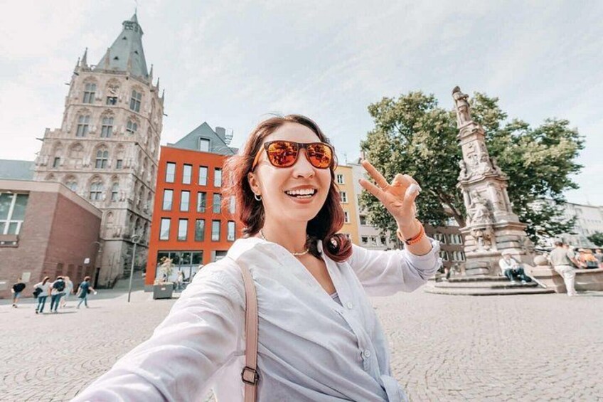 Una persona che si fa un selfie con un edificio storico e una statua sullo sfondo. 4