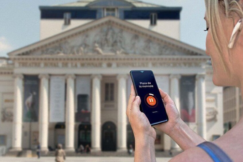 A person holding a smartphone with an app open, in front of a classical building with columns. 5