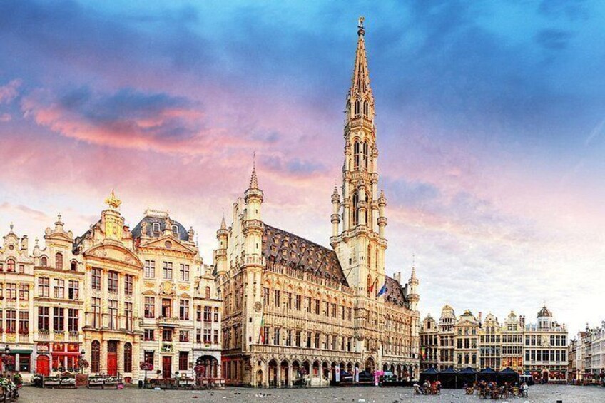 A historic building with a tall spire, ornate facades, and a large central entrance. 4