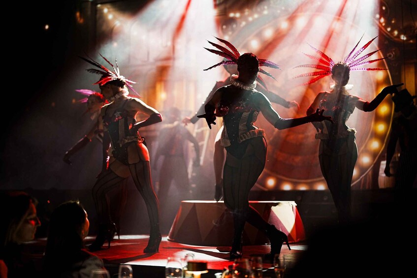 A stage performance with performers in elaborate costumes and feathered headdresses. 4