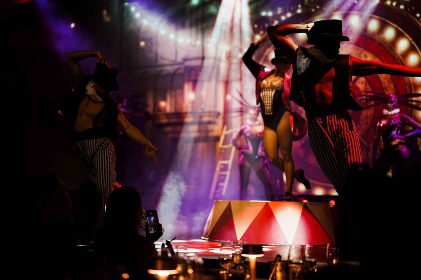 A stage with performers, a large circular structure, and stage lighting. 2