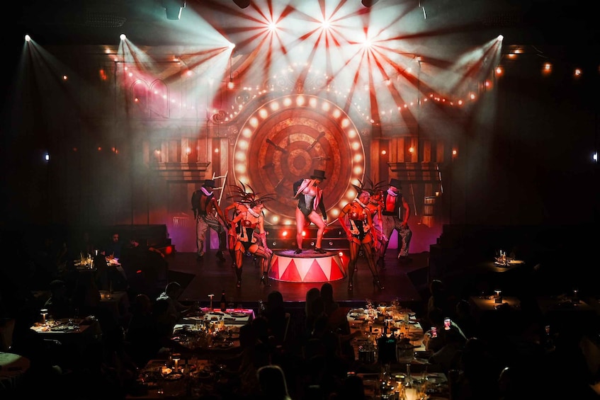 A stage performance with a large circular backdrop and spotlights. 5