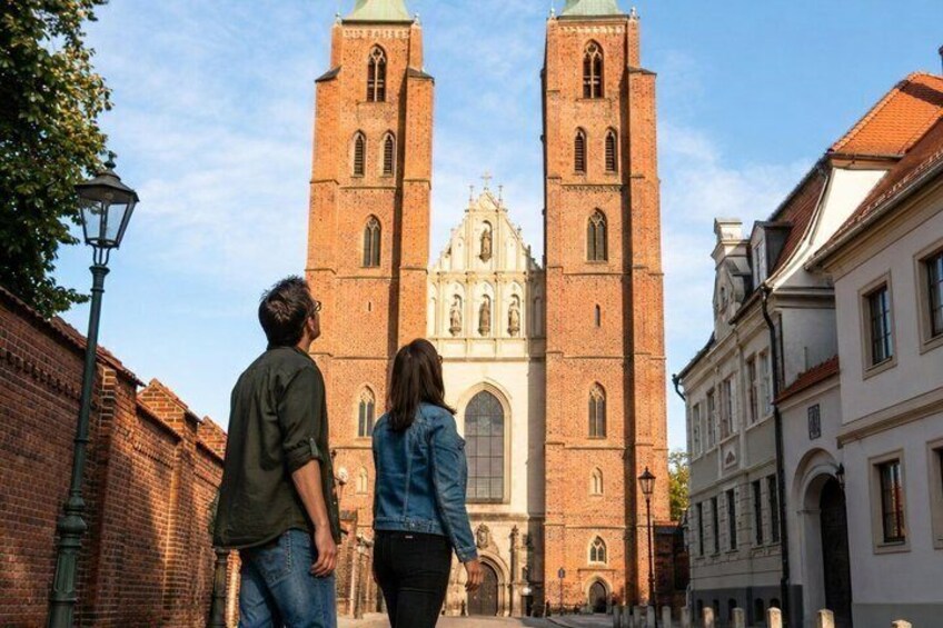 A historic church with two towers, a cobblestone street, and traditional buildings. 2