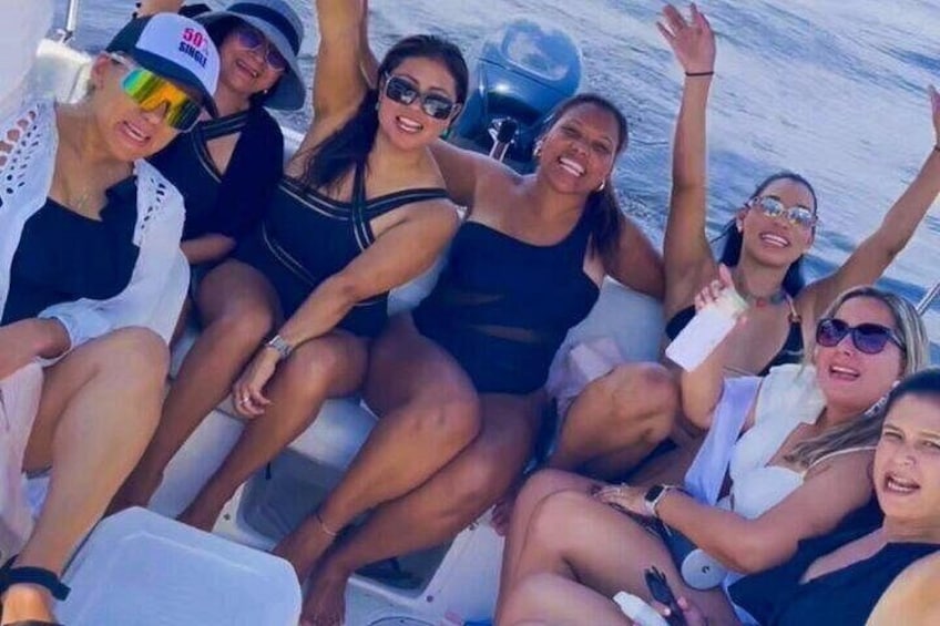 A group of people on a boat with water visible in the background. 1