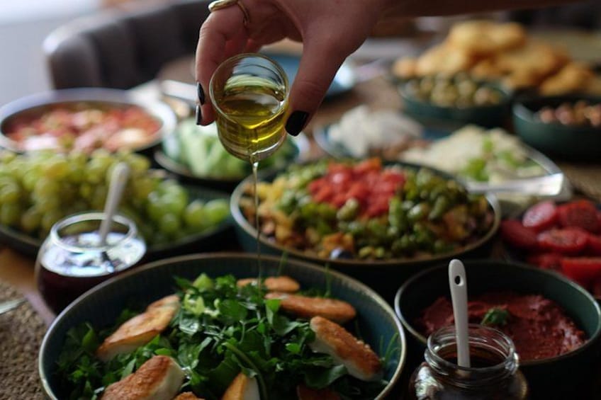 Diversos platos de comida con una mano vertiendo aceite. 5