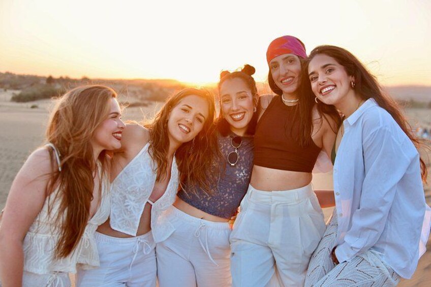 A group of people on a beach at sunset. 3