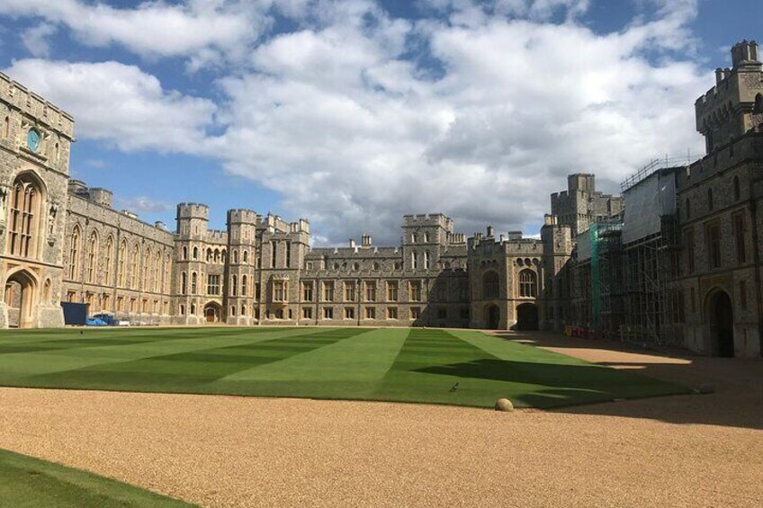 A large historic building with a green lawn in front. 3