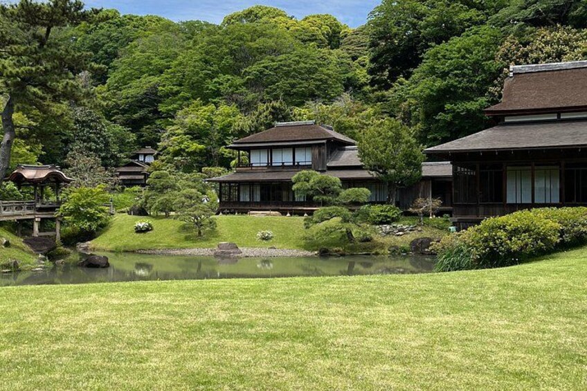 Traditional Japanese buildings, a pond, and lush greenery. 4