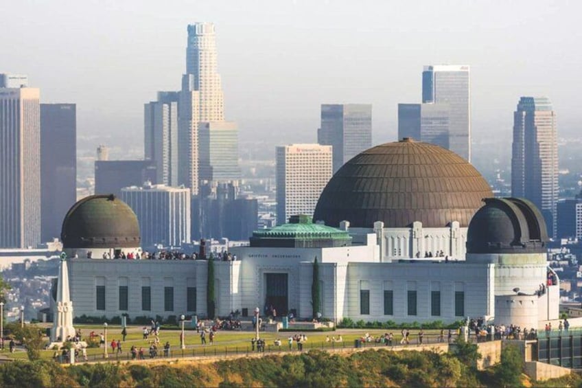 A large building with two domes, surrounded by a cityscape with tall buildings. 2