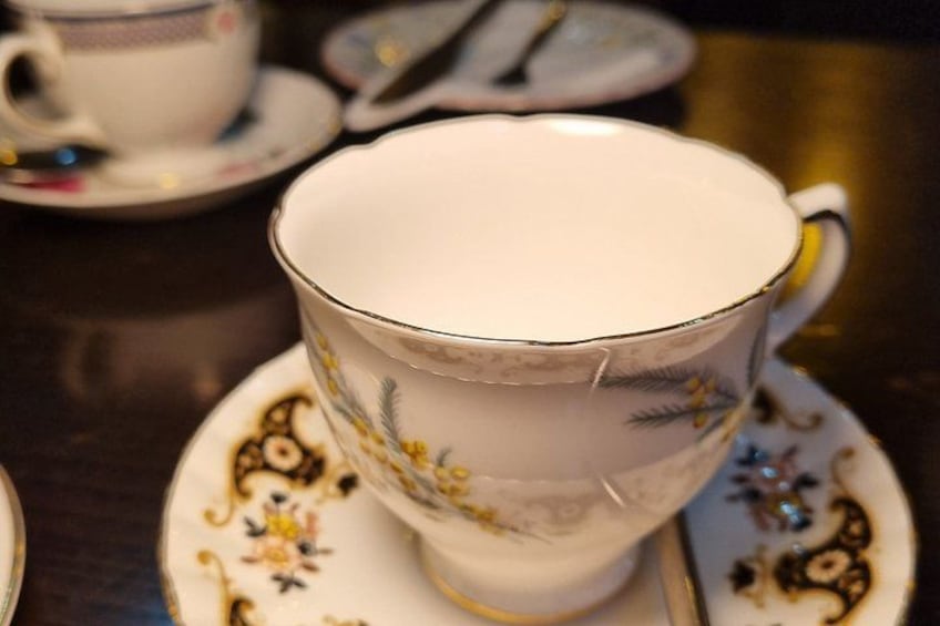 A white teacup with floral patterns on a saucer. 3