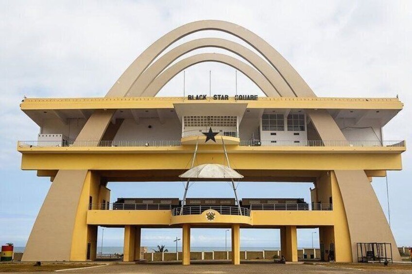 Un edificio grande y amarillo con una estrella en la parte superior y la inscripción 'BLACK STAR SQUARE' en la fachada. 2