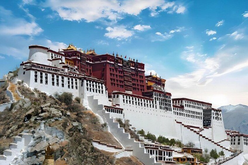 A large, multi-tiered building with red and white walls, situated on a hillside. 1