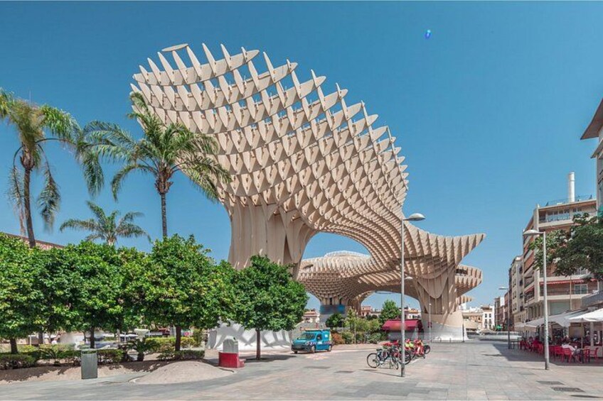 Een groot, modern sculptuur met een bladachtige structuur in een stadsplein. 2