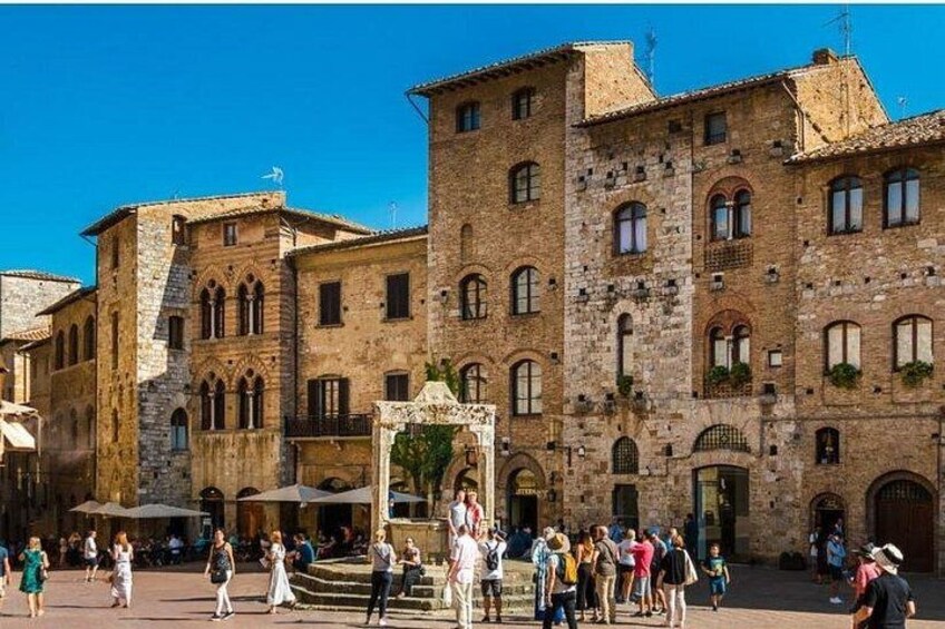 A historic stone building with arched windows and a central fountain. 3