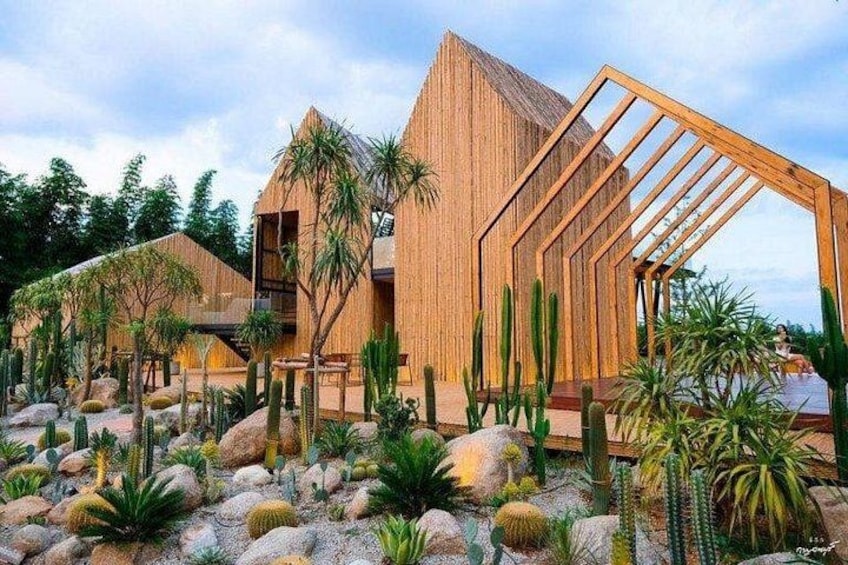 A modern building with a wooden facade, surrounded by a desert garden with cacti and rocks. 3