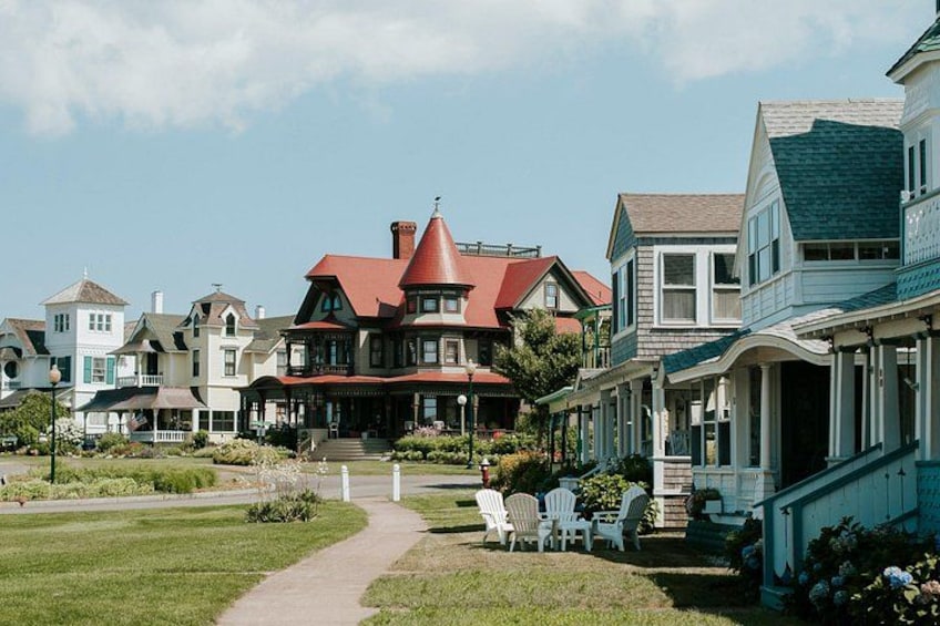 A large, red-roofed house with a porch and white chairs in front. 3