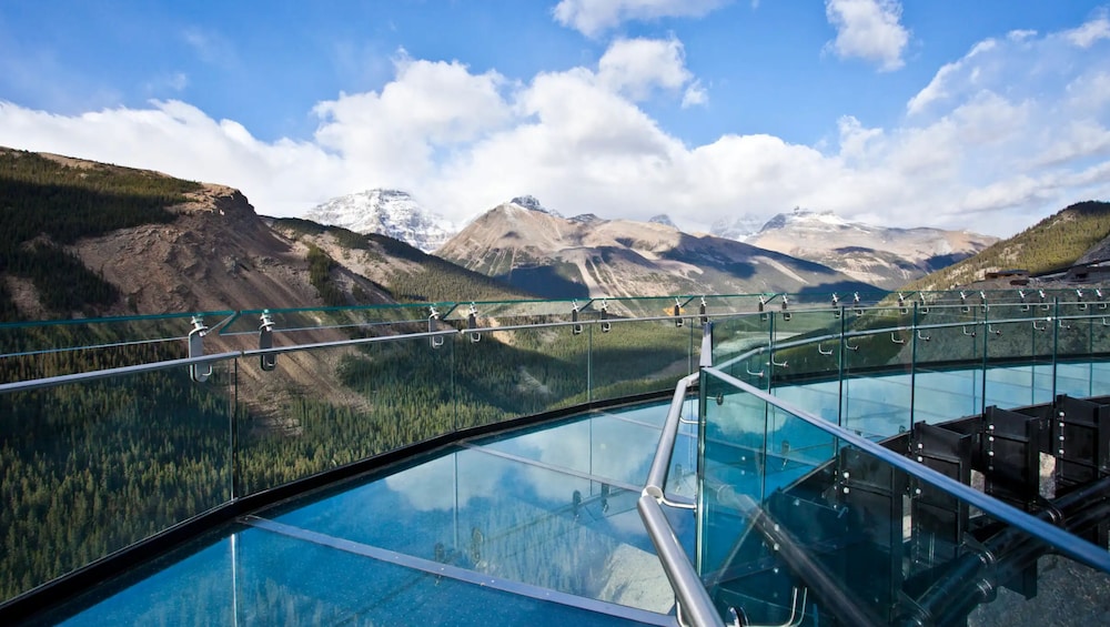 A glass-bottomed walkway with a mountain landscape in the background. 5