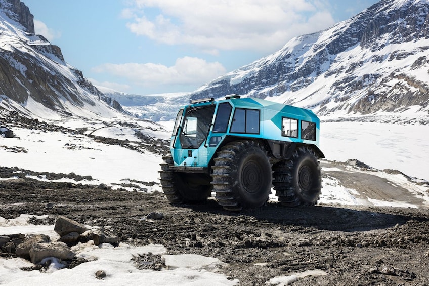 A blue snowcat on a snowy mountain path. 1