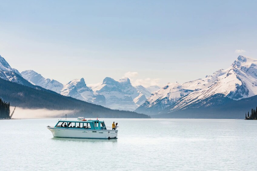 A boat on a calm lake with snow-capped mountains in the background. 3