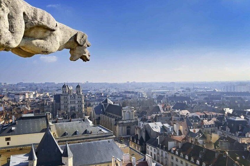 Eine Stadtansicht mit einem markanten Dom und einem steinernen Gargoyle. 4