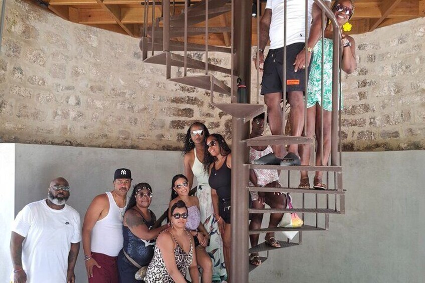 A group of people on a spiral staircase in a rustic building with stone walls. 1