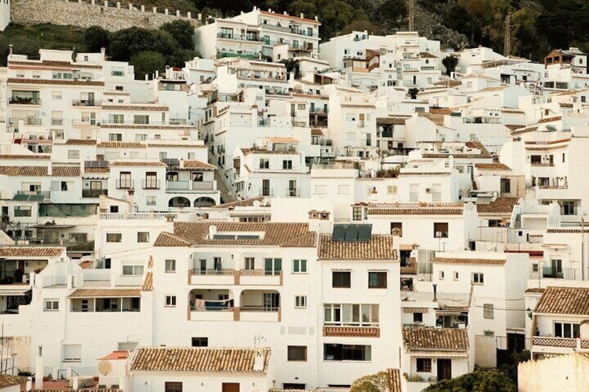 A densely packed urban area with white buildings and terracotta roofs. 2