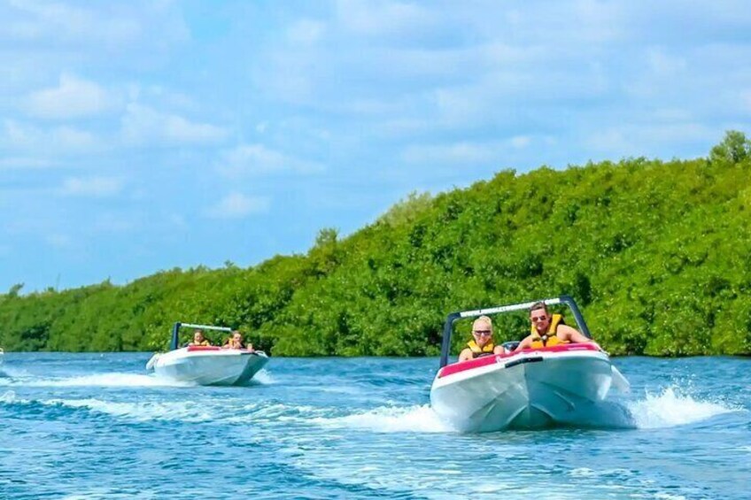 Two speedboats on a calm body of water with a forested shoreline in the background. 4