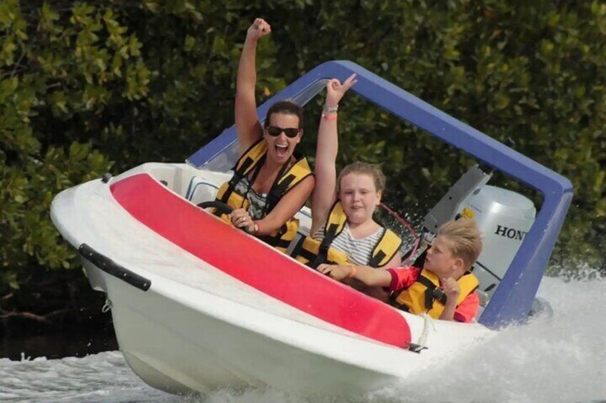 A boat with three people wearing life jackets, one raising an arm. 5