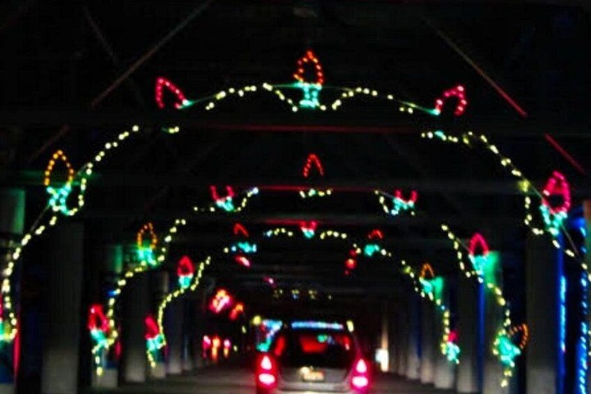 A tunnel with colorful lights and a car in the distance. 5