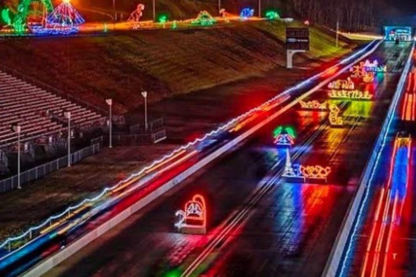A highway with colorful lights and a large illuminated structure. 3