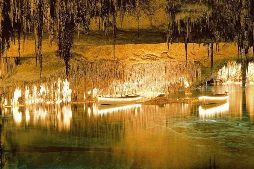 A serene lake with illuminated caves and boats. 3