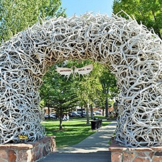 Holvikaari, joka on rakennettu yhteenpunotuista oksista, ja jossa on kyltti, jossa lukee: ”Jackson Hole, Wyoming”. 1