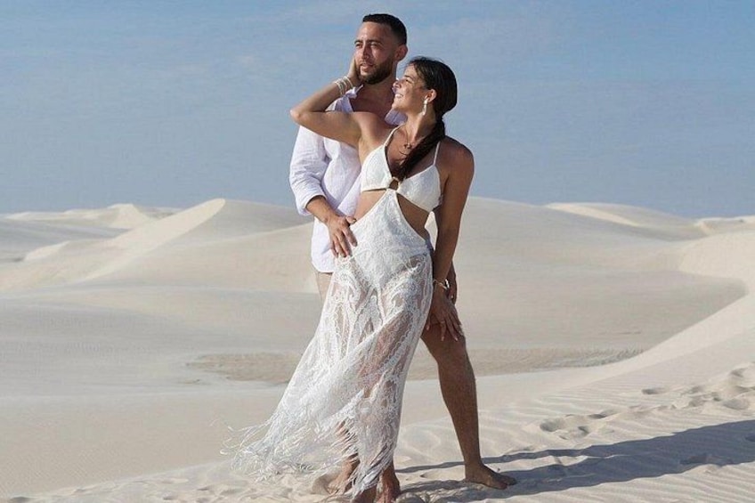 A couple in a desert landscape with sand dunes. 4
