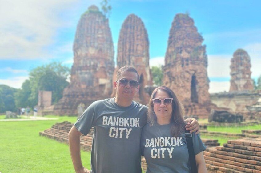Two people wearing 'Bangkok City' t-shirts standing in front of ancient stone structures. 5