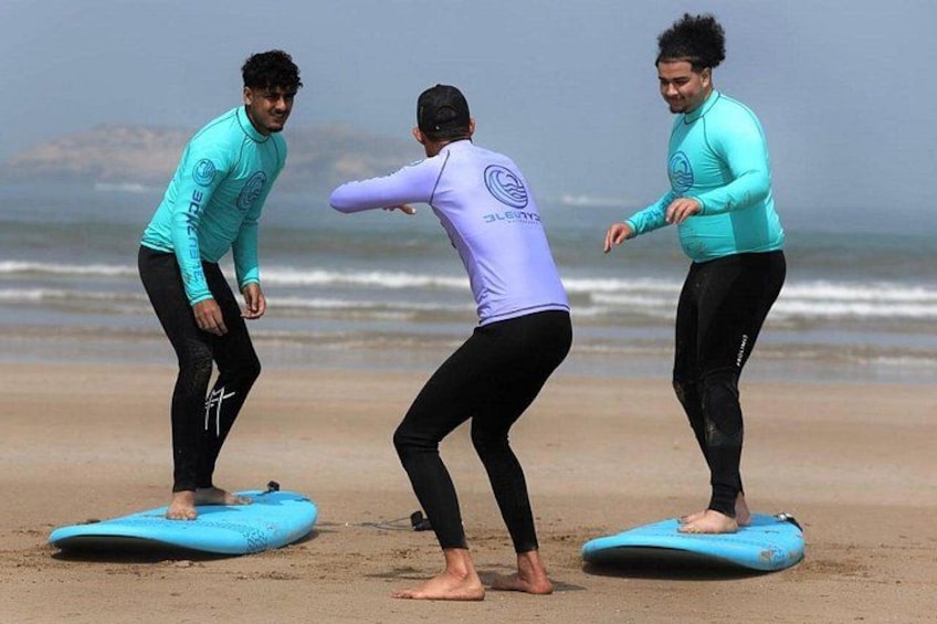 Three people on a beach with surfboards. 1