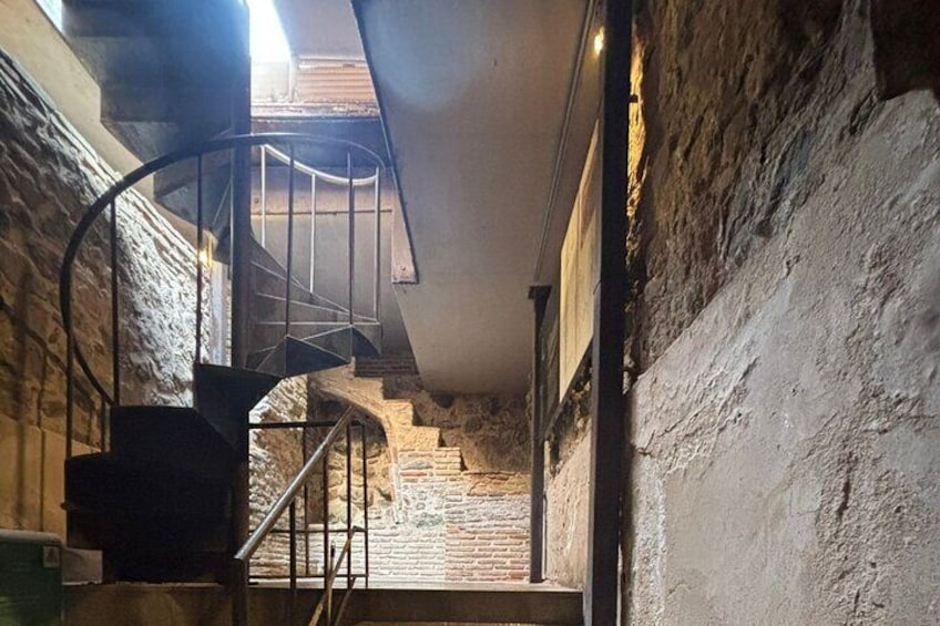 A spiral staircase in a stone-walled interior. 4