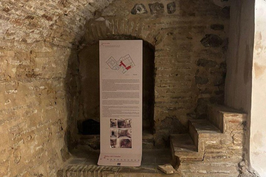 Een stenen gebouw met een poster waarop een kaart en tekst staan. 4