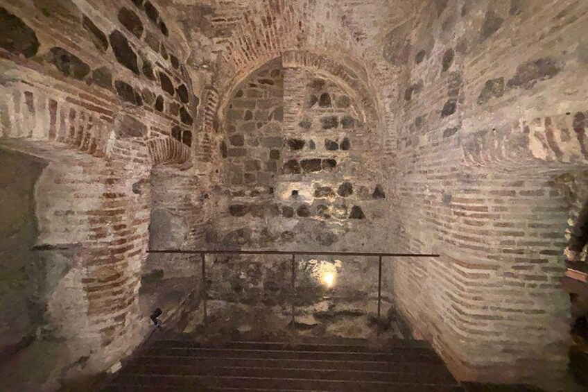 Een stenen trap die leidt naar een gewelfde stenen plafond in een historisch pand. 3