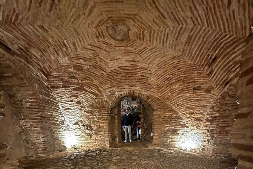 Ein steinerner Tunnel, in dem sich eine Person in der Mitte befindet. 3