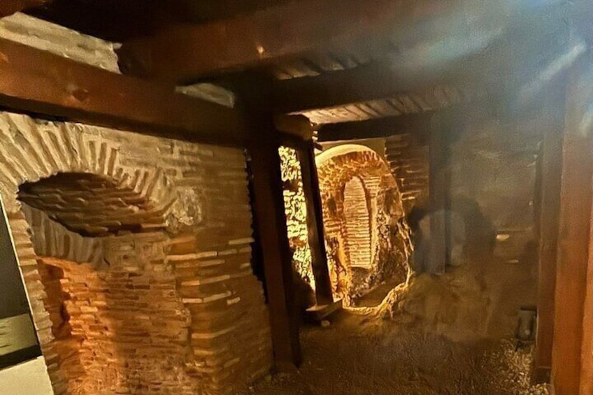 A stone archway and a stone wall with a carved design. 5