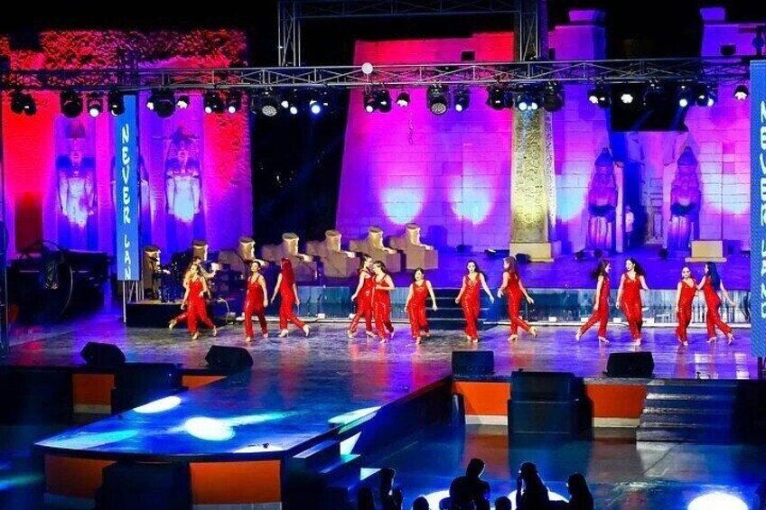 A stage with dancers in red costumes performing. 2