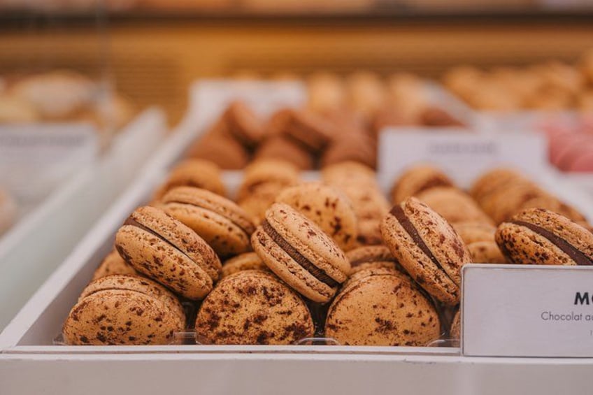 A display of chocolate macarons in a bakery. 3
