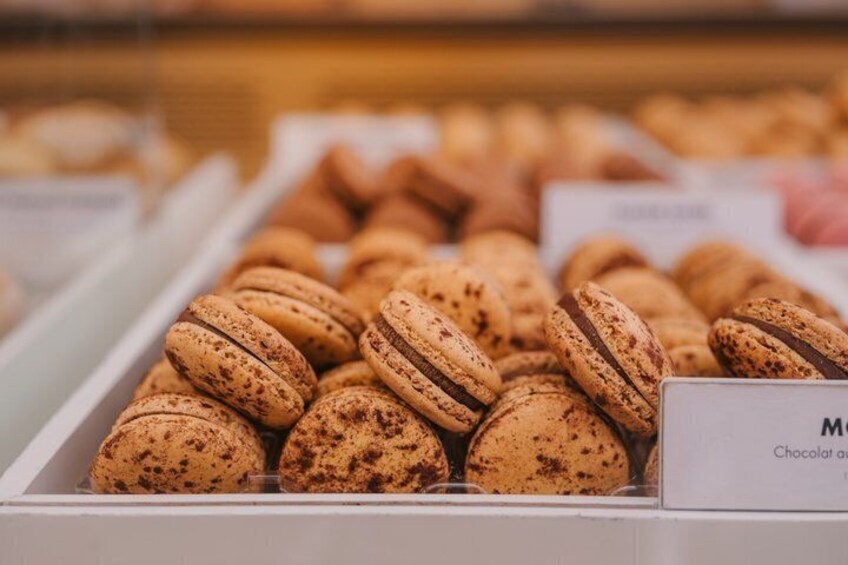 A display of chocolate macarons in a bakery. 3